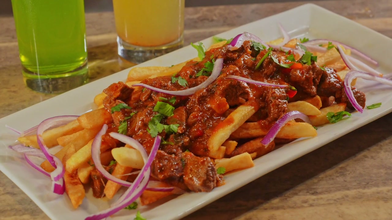 A plate of chips and nyama with drinks at Shebelle